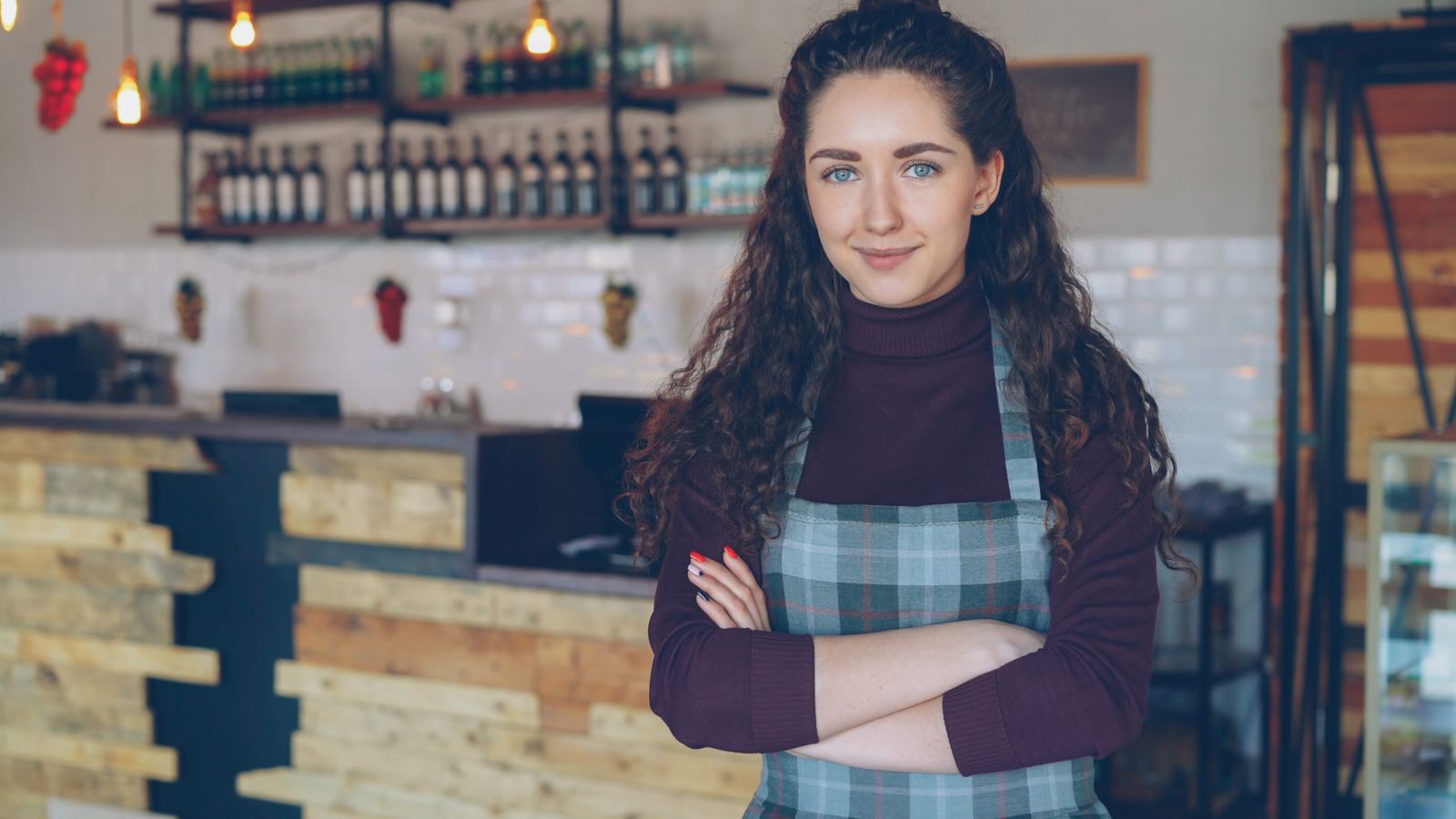 Trotse eigenaar met gekruiste armen in een sfeervolle eigen zaak