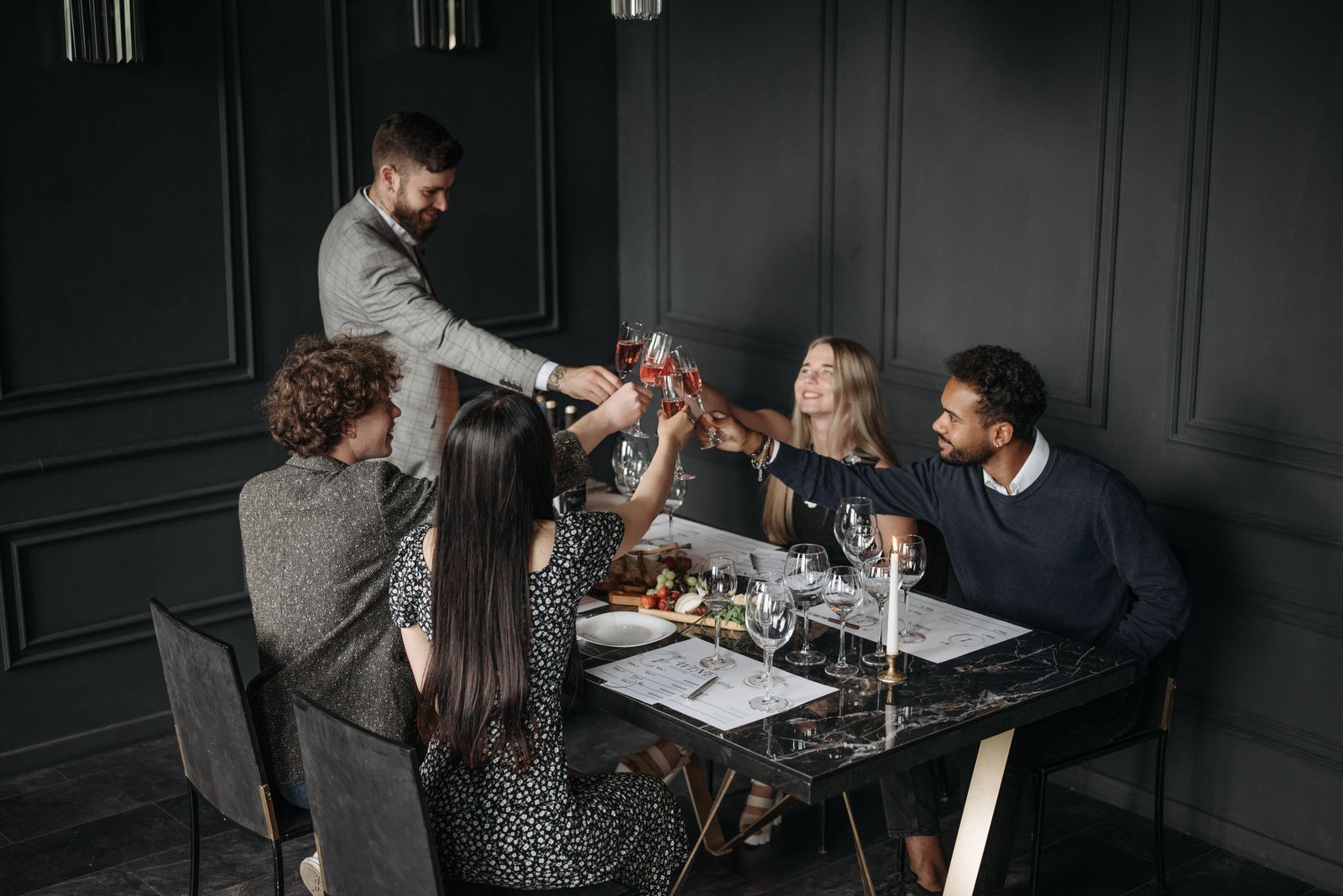 Gezelschap proost met wijnglazen tijdens een diner
